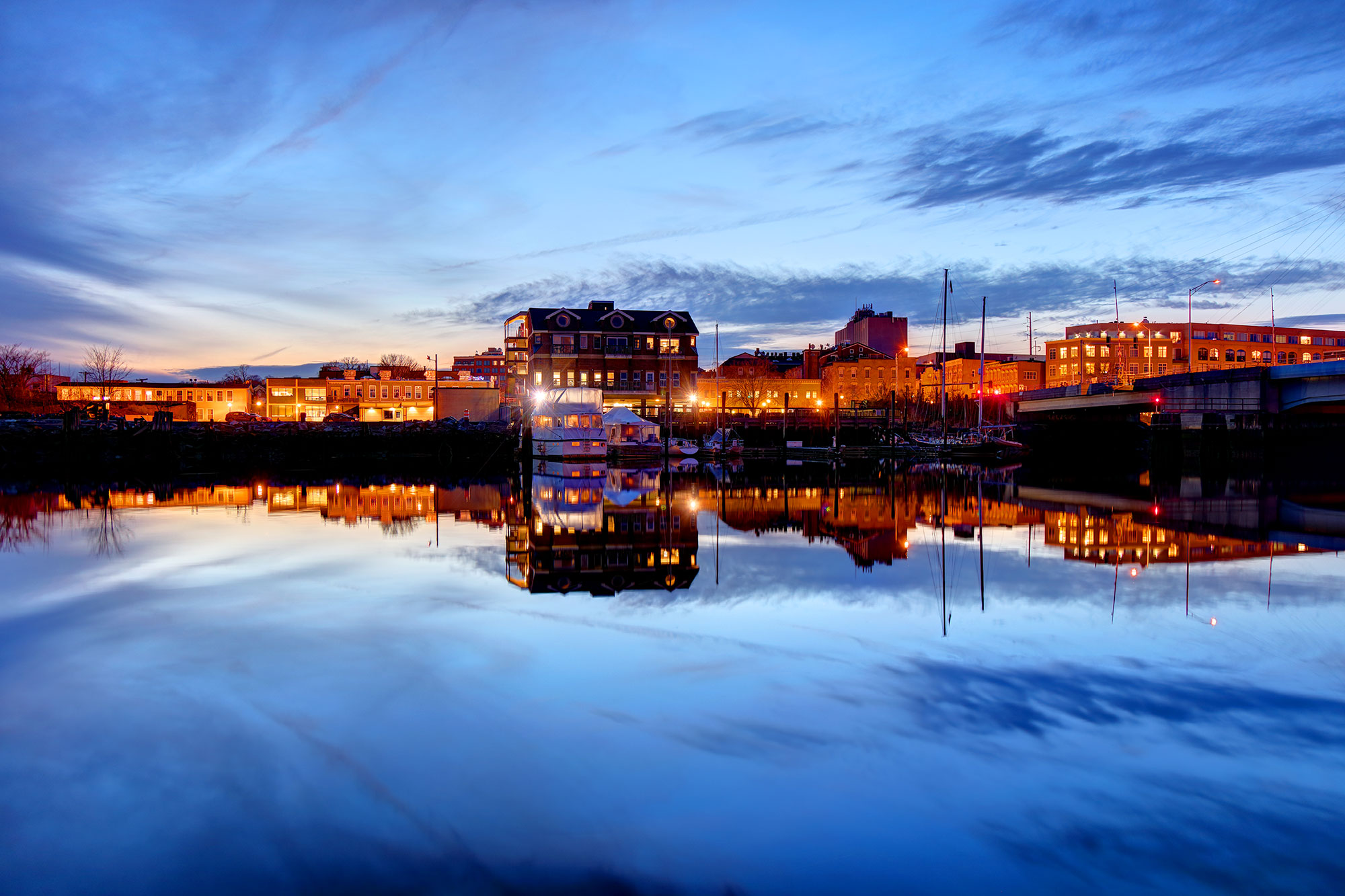 View of a small marina from across the water at dusk